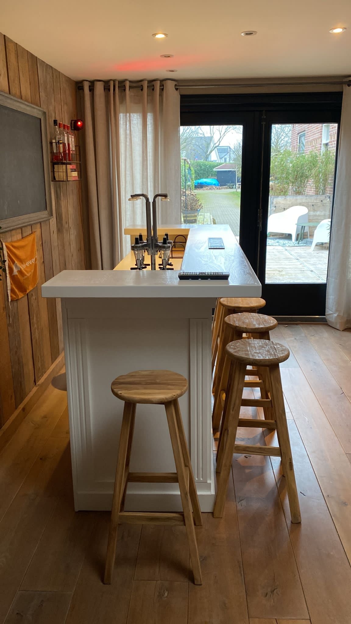 Teakhouten barkrukken geplaatst aan een bar vanuit de hoek genomen