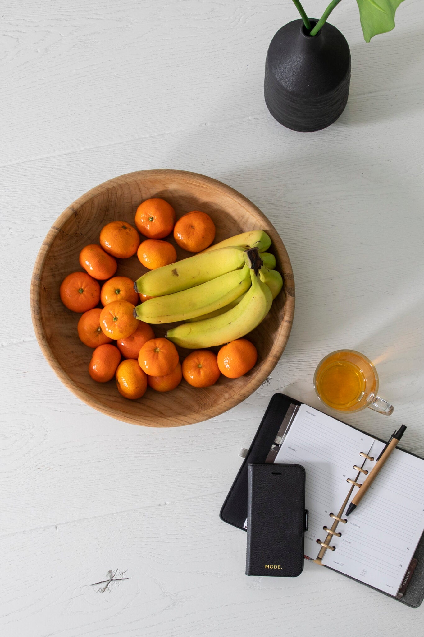 Fruitschaal gemaakt van teakhout gevuld met fruit naast decoratie