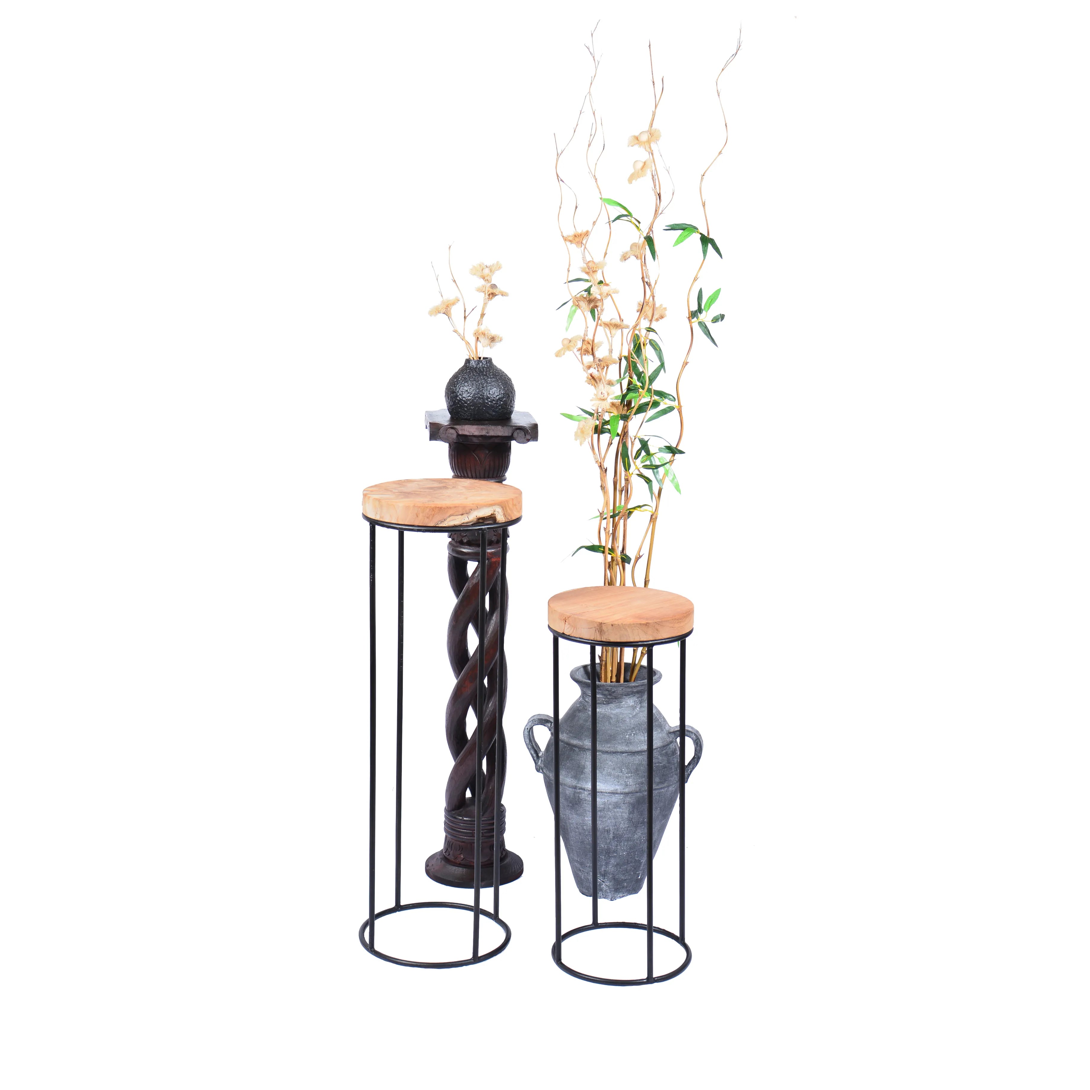 Ronde teakhouten bijzettafels als plantentafel met vaas en decoratie.