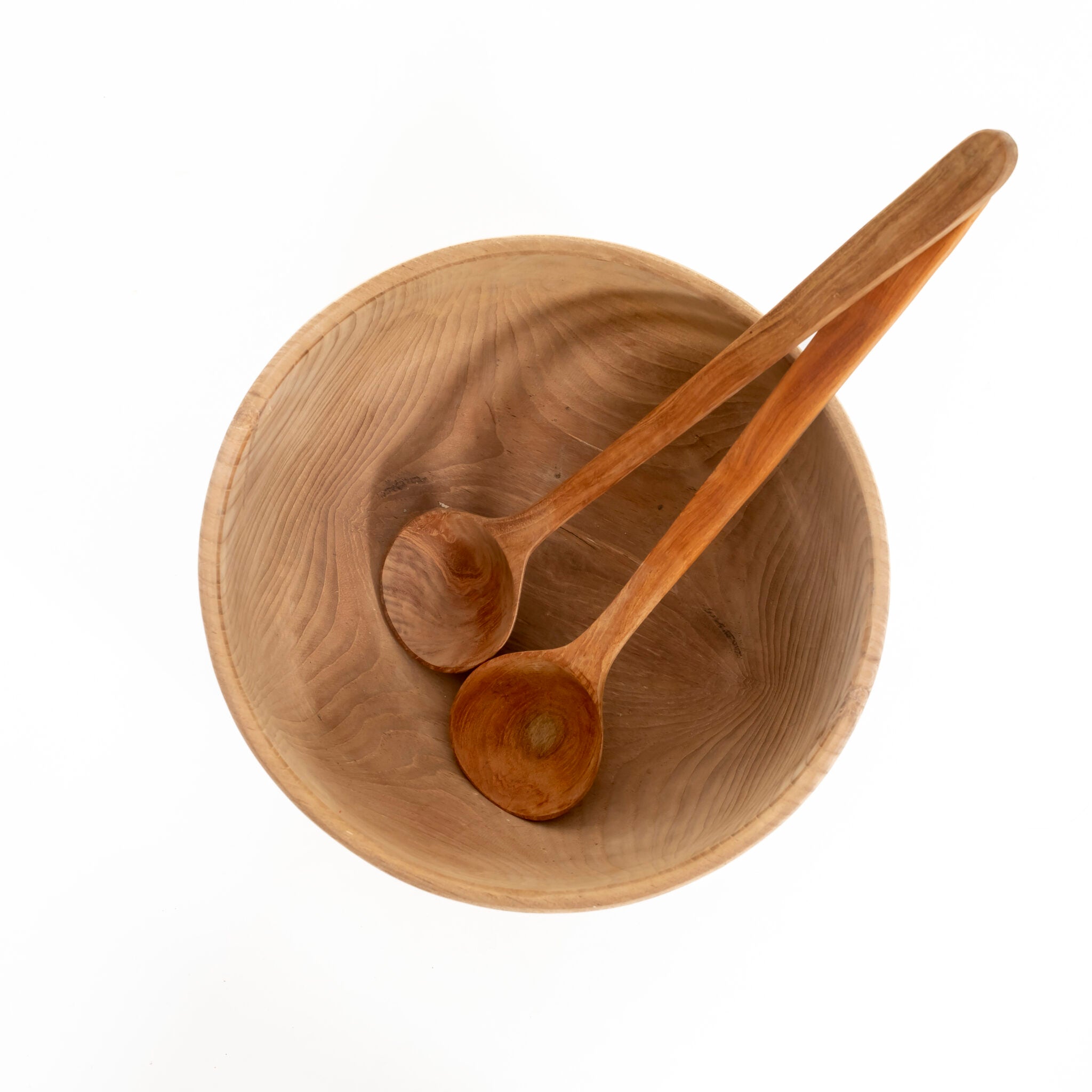 Bovenaanzicht van twee teakhouten lepels in teakhouten kom