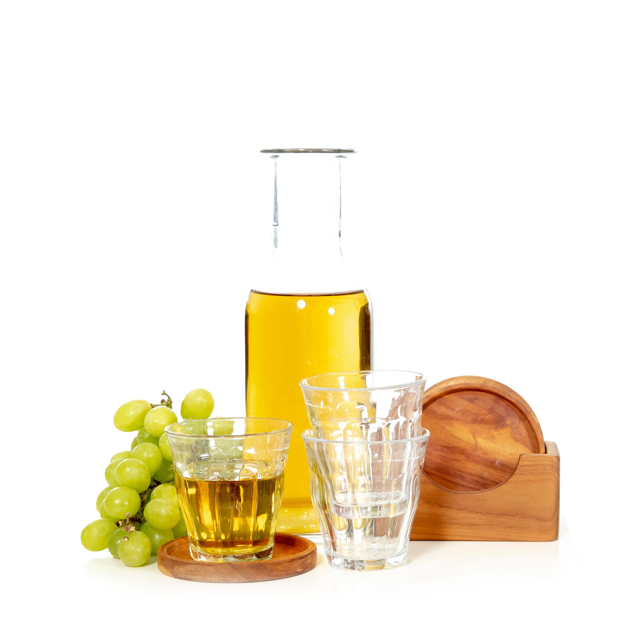Teakhouten onderzetters in houder en een onderzetter met een glas drinken erop