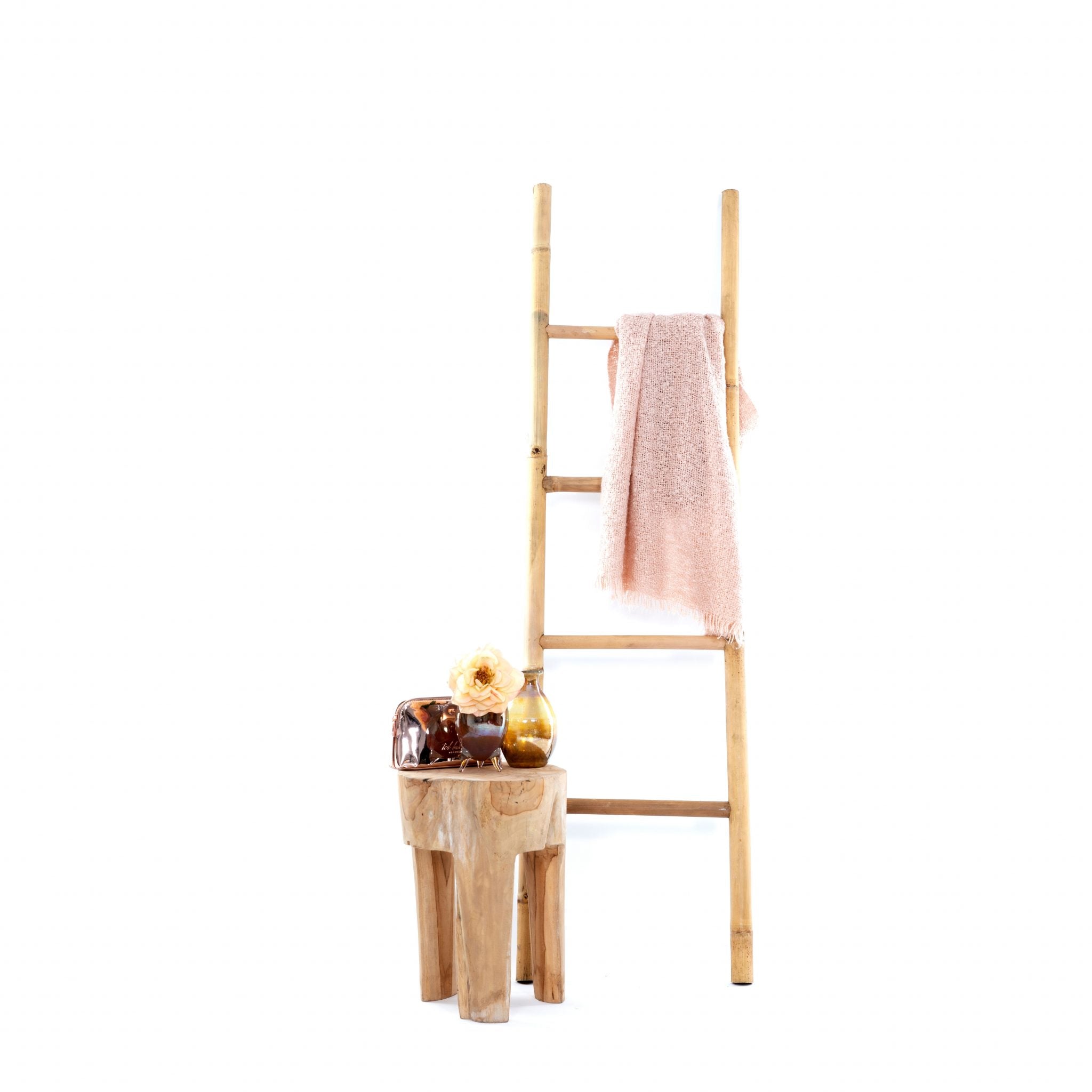 Decoratieve teakhouten ladder met handdoek over de ladder en klein tafeltje ervoor