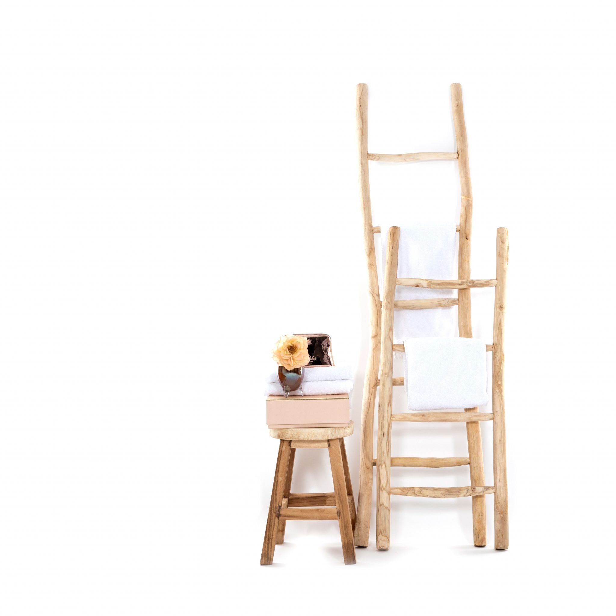 Twee decoratieve teakhouten ladders met handdoeken erover en klein tafeltje erbij