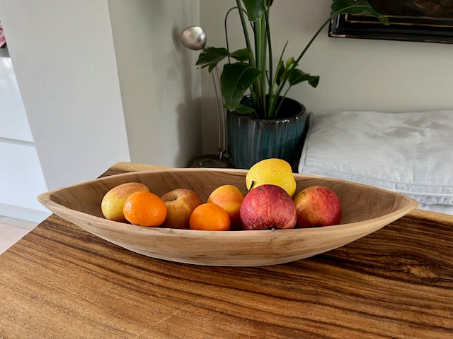 Teakhouten fruitschaal prauw gevuld met fruit in een woonkamer