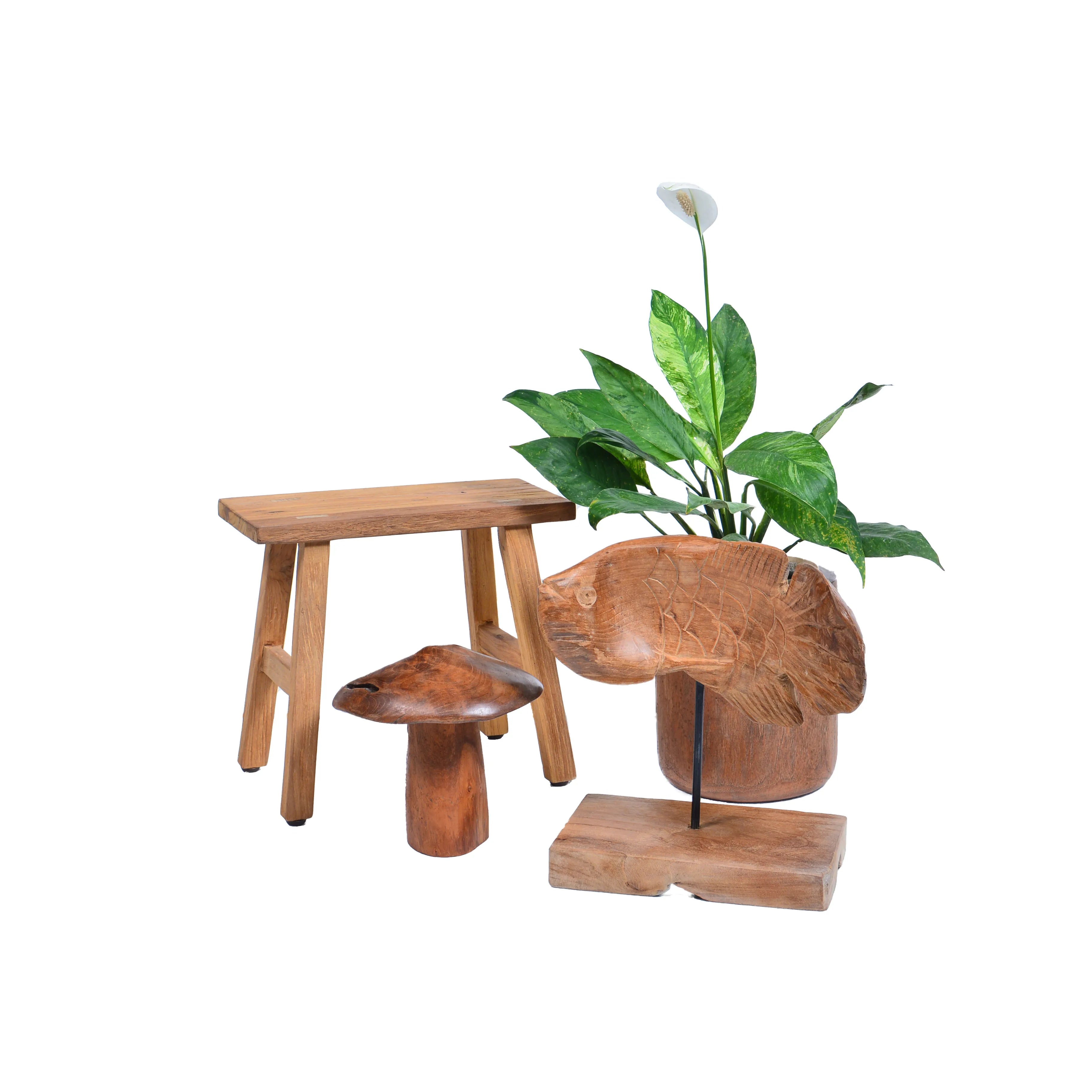 Houten vis decoratie in interieur met plant en krukje.